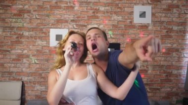 Kaç şarkı şarkı - karaoke takım. iki adam ve kadın kanepede oturan bir mikrofona şarkıları söyleyerek. 4k, ağır çekim