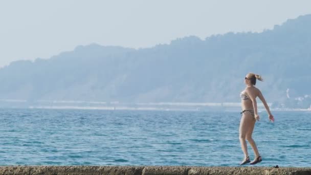 Vista sulle isole della baia. Teleobiettivo sparato. donna sul frangiflutti guarda la spiaggia nella nebbia, 4k, rallentatore — Video Stock