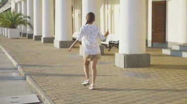 Genç güzel kız parkta dans. kız dans ediyor ve tatil beldesi yürüyüş atlar. steadicam vurdu. 4k, ağır çekim