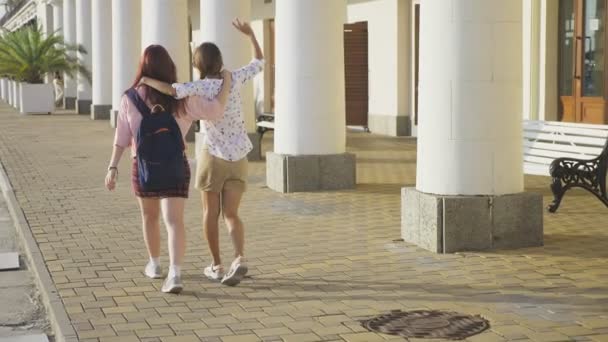 Zwei Freundinnen, junge schöne Mädchen, die im Park tanzen. Mädchen tanzen und springen und spazieren durch die Kurstadt. Steadicam-Aufnahme. 4k, Zeitlupe — Stockvideo