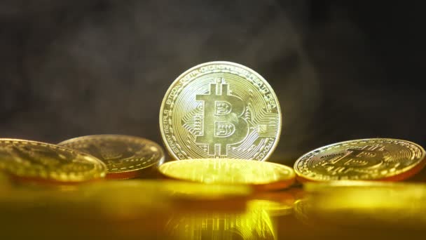 Koin emas, bitkoyny di latar belakang tabir asap dalam terang safitov. close-up. Mata uang Crypto. Mata uang virtual, 4k — Stok Video