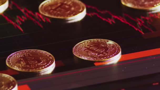 Monedas de oro, bitcoins en un fondo de brillantes gráficos financieros. Gráficos de negocios de cerca. Criptomoneda. Moneda virtual, grande 4k . — Vídeo de stock