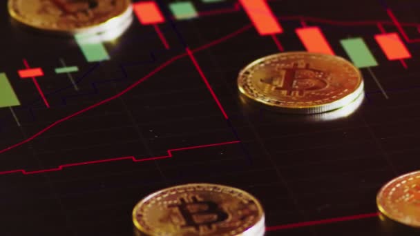 Goldmünzen, Bitcoins auf einem Hintergrund heller Finanzgrafik. Geschäftsgrafik aus nächster Nähe. Kryptowährung. virtuelle Währung, große 4k. — Stockvideo