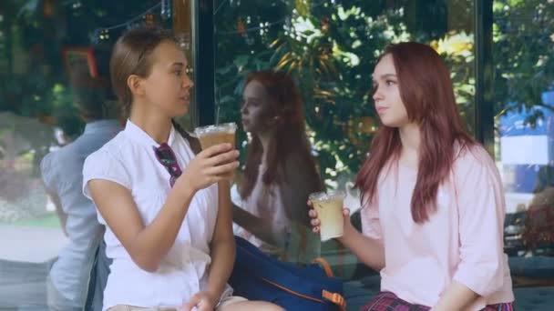 Dos chicas están hablando en un café al aire libre. beben cócteles en la calle. 4k, disparo en cámara lenta . — Vídeos de Stock