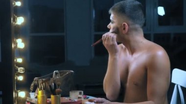 travesti-diva. Bir travesti kavramı. Adam-aktör bir kadına dönüşür. bir adam, yüzünde bir makyaj uygulanır. Aynanın önünde odaya. 4k, ağır çekim, steadicam çekim