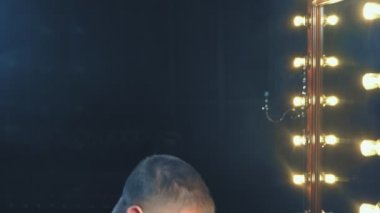 travesti-diva. Bir travesti kavramı. Adam-aktör bir kadına dönüşür. bir adam, yüzünde bir makyaj uygulanır. Aynanın önünde odaya. 4k, ağır çekim, steadicam çekim