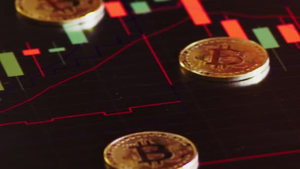 Moedas de ouro, bitcoins em um contexto de gráficos financeiros brilhantes. gráficos de negócios close-up. Criptomoeda. Moeda virtual, grande 4k . — Vídeo de Stock