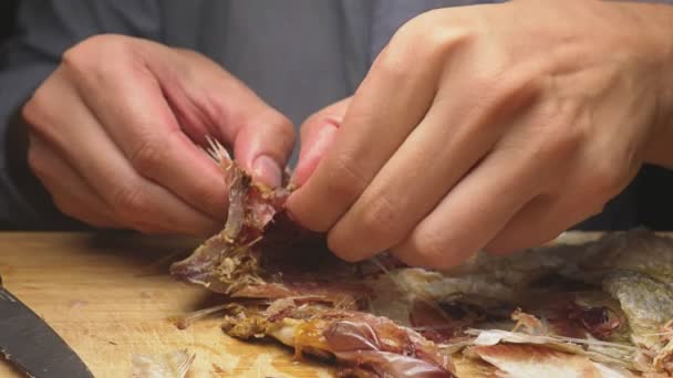 Close-up. Mannelijke handen schoon de gedroogde gezouten vis. Op de snijplank. 4 k slow-motion — Stockvideo