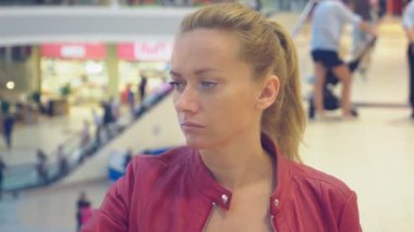 Müşteriler geçen ortasında bir süpermarkette sıkılmış bir kadın portresi. 4 k. bulanıklık