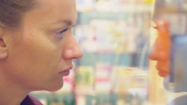 Depodaki cam vitrin, arayan bir kadın. 4k, arka plan bulanıklık.