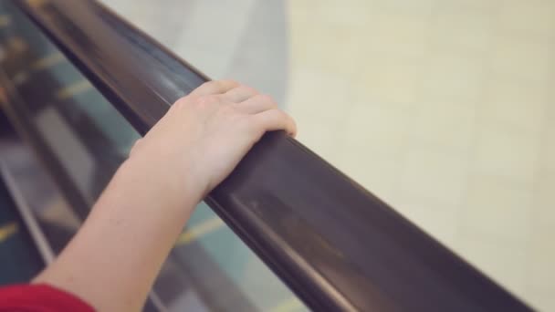 Κίνηση του γυναικείου χεριού για την κυλιόμενη σκάλα κιγκλιδώματα. 4 k, αργή κίνηση, γκρο πλαν. — Αρχείο Βίντεο