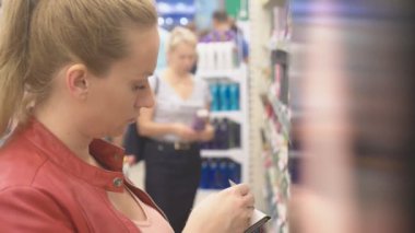 Depodaki bir vitrin, arayan bir kadın. 4k, arka plan bulanıklık