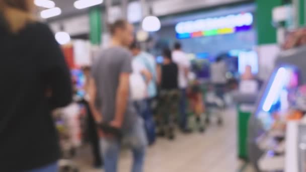 La gente está comprando en un supermercado, desenfocado fondo borroso. 4k — Vídeo de stock