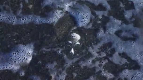Ένα ανθρώπινο κρανίο στην παραλία, κάτω από τα κύματα του νερού. 4k, αργή κίνηση — Αρχείο Βίντεο