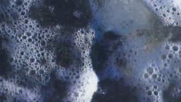 Um crânio humano na praia, sob as ondas de água. 4k, câmera lenta — Vídeo de Stock