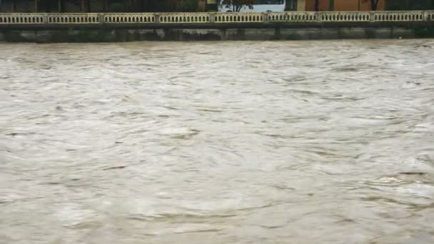 灰色不透明的河水在河床中迅速流过 市中心有围墙 运河上的洪水 慢动作 — 图库视频影像