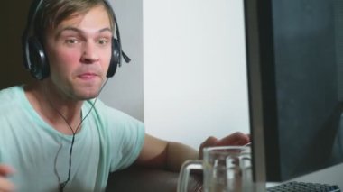 teknoloji, Oyunlar, eğlence, oyun ve insanlar kavramı. evde bir bilgisayar oyunu oynamak, bira içme ve pizza yemek genç bir adam. 4k, ağır çekim