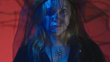 4k, ağır çekim, Cadılar Bayramı. Kostüm korkunç bir cadı kadın yemin ediyor kameraya, seyir yakın çekim