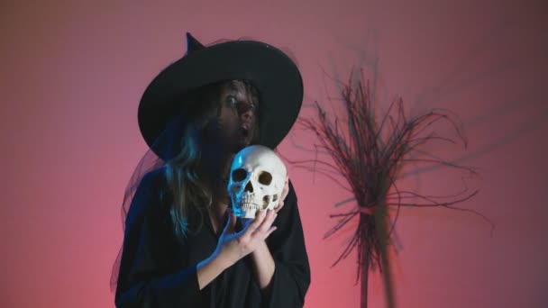 4K, rallentatore, Halloween. Una donna in costume da strega terribile balla con un teschio in mano. copia spazio — Video Stock