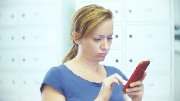 femme avec un téléphone à la recherche d'un produit dans un magasin d'entrepôt. une femme utilise son smartphone. 4k 