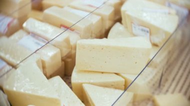 Vitrin kıyılmış peynir parçalarını, bir süpermarket, gıda, süt ve süt ürünleri kavramı ile. 4k, yakın çekim