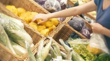 Bir kadın bir süpermarkette sebze, kabak satın alma