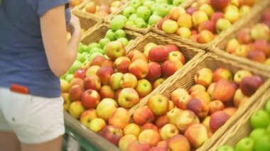 Genç kadın elma meyve sebze süpermarket Market'teki seçme. 4k