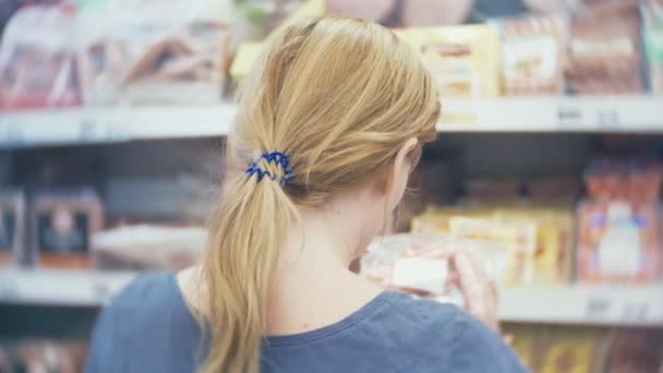 Жінка купує ковбасу в супермаркеті, 4k — стокове відео