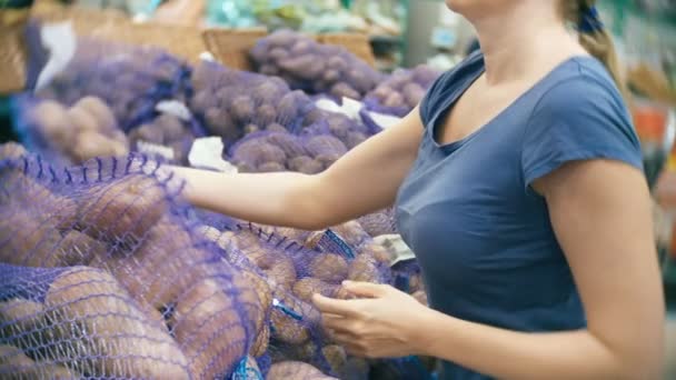 Uma mulher num supermercado a comprar vegetais, batatas . — Vídeo de Stock