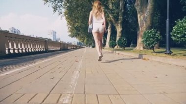 Güzellik kız zevk doğa. Çalışan ve cadde boyunca Rıhtımlar üzerinde atlama. Eğleniyor güzel genç kadın sokak resort şehir. Özgürlük kavramı. 4k, ağır çekim, steadicam.