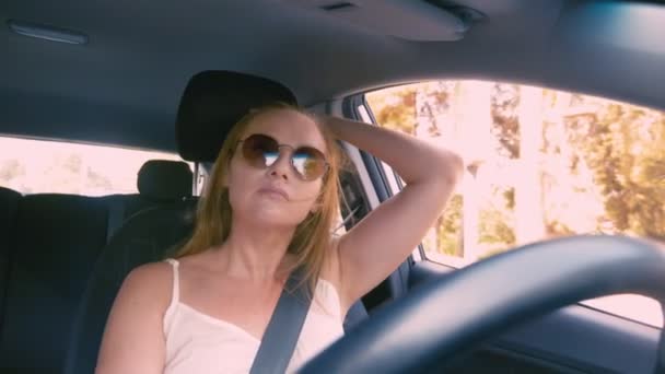 Mujer rubia hermosa feliz en gafas de sol que conducen un coche. 4k, cámara lenta . — Vídeo de stock