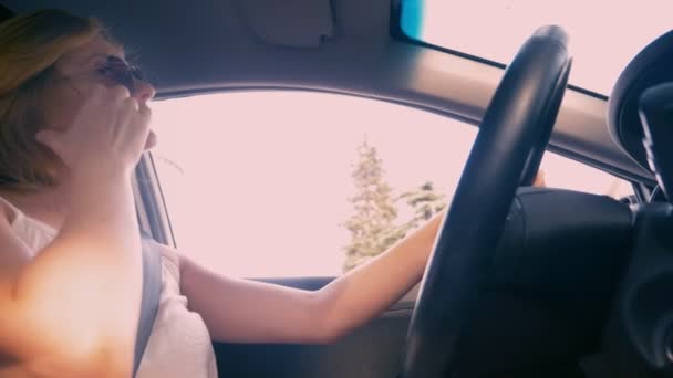 Ευτυχής όμορφη ξανθιά γυναίκα σε γυαλιά ηλίου οδήγηση ενός αυτοκινήτου. 4k, αργή κίνηση. — Αρχείο Βίντεο