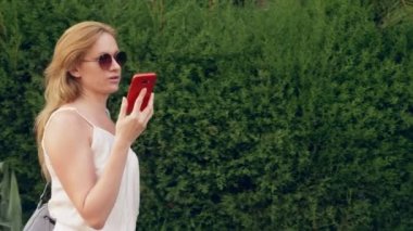 bir sinir konuşma, duygu ağrı ve baş ağrısı olan kadın sokakta, telefonda söz vurguladı. Steadicam vurdu. 4k, ağır çekim çekim