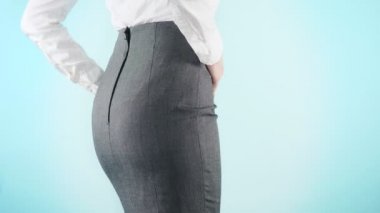 Renkli bir arka plan üzerinde güzel bir iş kadını. yakın çekim etek. kod elbise, kalça hareket. 4k, ağır çekim