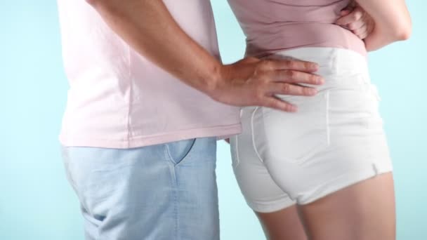 Fecha. ancas. imagem de moda de um jovem casal sexy, uma briga em um fundo azul claro, 4k, câmera lenta — Vídeo de Stock