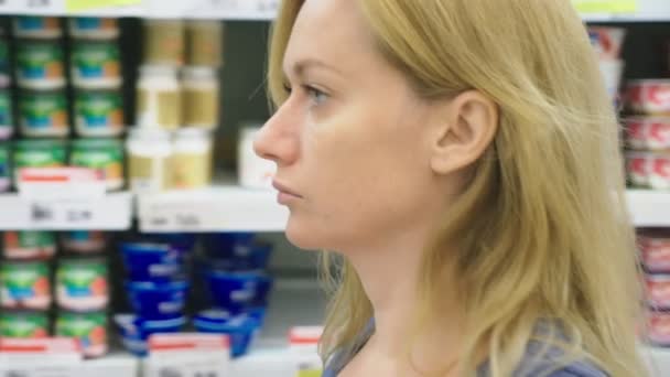 Une femme dans un supermarché passe devant les comptoirs. 4k, gros plan — Video