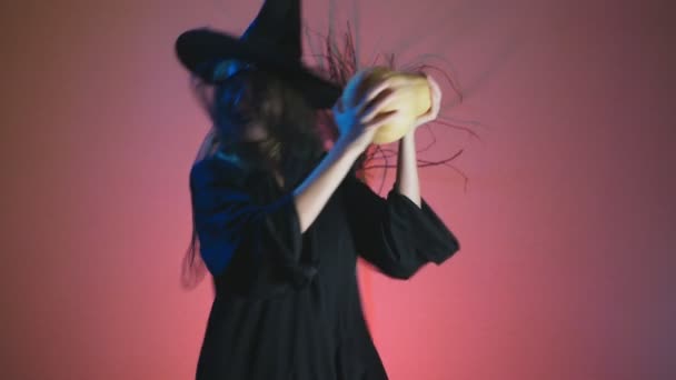 4k, lassú mozgás, Halloween. Egy asszony a rettenetes boszorkány tánc ruha a sütőtök, a kezében. hely másolás — Stock videók