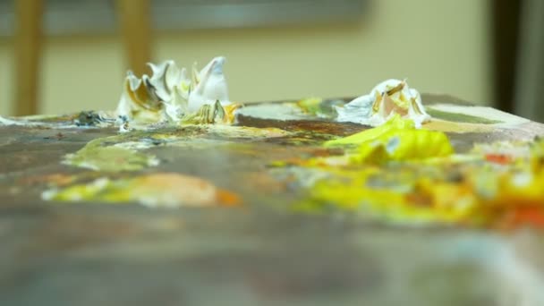 Paleta de arte de madeira com tintas a óleo. Misturando cores juntas, close-up, 4k — Vídeo de Stock