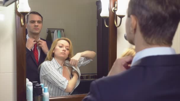 Casal, marido e mulher se reúnem no banheiro em frente ao espelho. para ser perfumado com perfume. 4k, câmera lenta — Vídeo de Stock