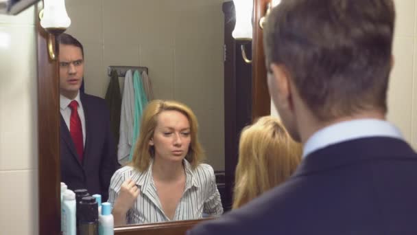 Casal, marido e mulher se reúnem no banheiro em frente ao espelho. 4k, câmera lenta — Vídeo de Stock