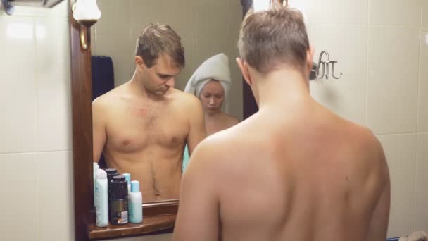 Gyönyörű pár, a férfi és a nő, együtt moshatók, a fürdőszobában a tükör előtt. 4k, lassú mozgás, egy nő a fogmosás, egy férfi borotválkozási. — Stock videók