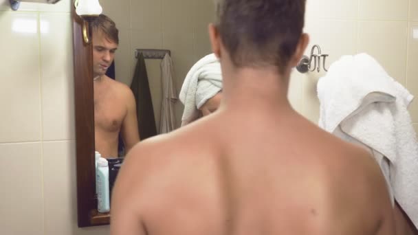 Vackert par, man och kvinna, tvätta tillsammans i badrummet framför spegeln. 4k, ultrarapid, tar kvinna rakhyveln från hennes make och startar rakning hennes armhålor — Stockvideo