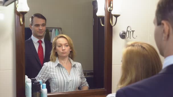 Paar, man en vrouw verzamelen in de badkamer voor de spiegel. 4k, slow-motion — Stockvideo