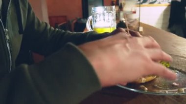 Yakın çekim. Bir adam bir hamburger yiyor. Lezzetli hamburger yeme işlemi.