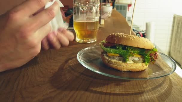 Γκρο πλαν. Ένας άνθρωπος τρώει ένα burger. Η διαδικασία της τρώει νόστιμα μπιφτέκια. — Αρχείο Βίντεο
