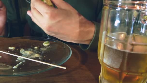 Close-up. Um homem está a comer um hambúrguer. O processo de comer deliciosos hambúrgueres . — Vídeo de Stock