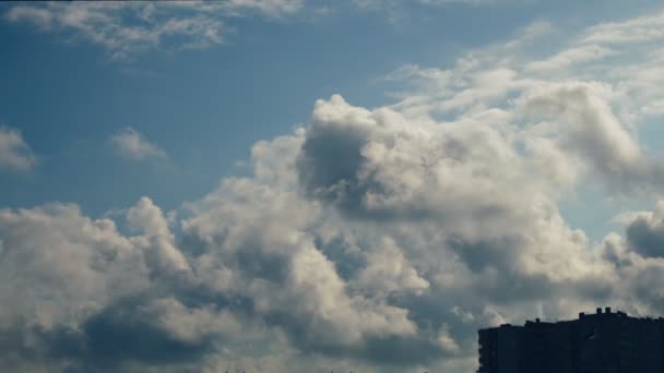Wolken über dem Haus. Wolken ziehen den blauen Himmel, Bäume lehnen sich vom Wind. — Stockvideo