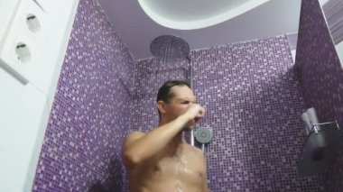 Bir kişi duş alırken saçını yıkar. Vücut Bakımı evde. yetişkinler için günlük yordamı.