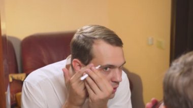 metrosexualism kavramı. yakışıklı bir adam bir ayna önünde onun yüzü ilgilenir. karşısında, her gün makyaj şekillendirme yapar. 4k, ağır çekim