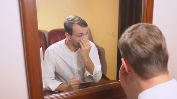 Koncept metrosexualism. pohledný muž v zrcadle se stará o jeho tváře. Ano, konturování obličeje, každodenní líčení. 4k, pomalý pohyb — Stock video